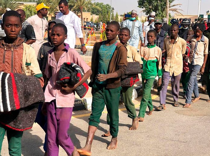 Freed Nigerian schoolboys arrive back home, escorted by soldiers