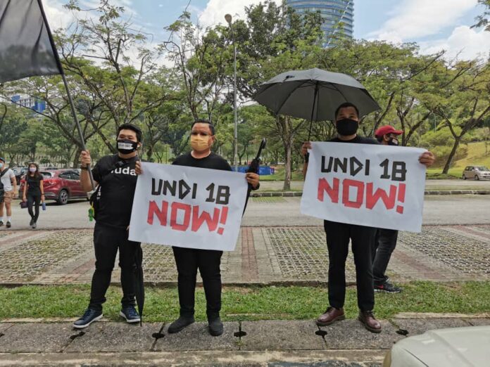 ‘Where is our vote?’ Youths sit for 18 minutes in front of Parliament to protest the delay of Undi18