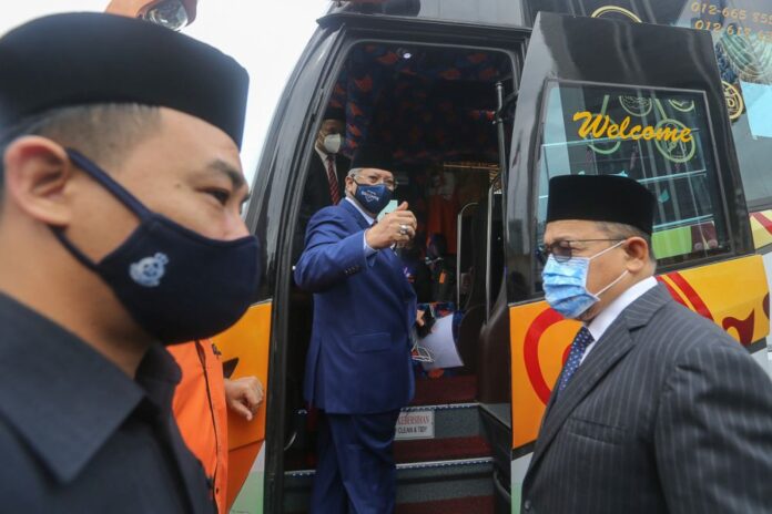Buses ferrying Umno, Bersatu MPs arrive at Istana Negara for audience with King (VIDEO)