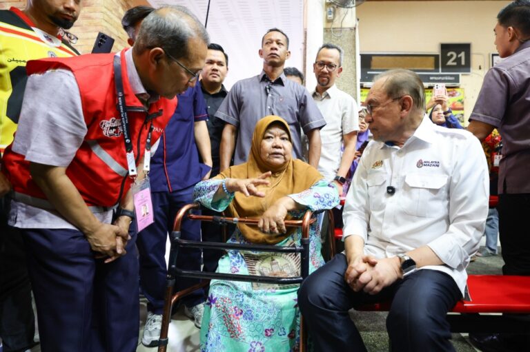 Disabled woman braves drizzle on three-wheeler for chance to meet Anwar in Seremban
